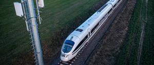 Ein Testzug der Deutschen Bahn fährt an einem Antennenmast vorbei (Luftaufnahme mit einer Drohne). 