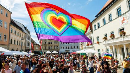 Teilnehmer des Christopher Street Day (CSD) mit Regenboggenflagge.