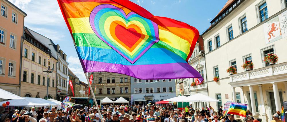 Teilnehmer des Christopher Street Day (CSD) mit Regenboggenflagge.