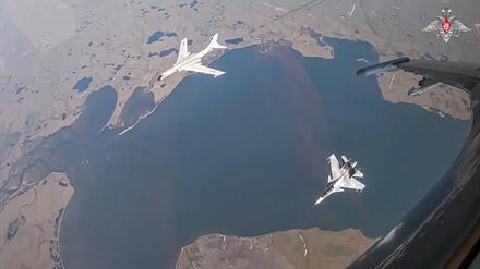 Auf diesem vom Pressedienst des russischen Verteidigungsministeriums über AP veröffentlichten Videostandbild ist ein H-6K-Langstreckenbomber der chinesischen Luftstreitkräfte (oben links) zu sehen. Dieser wird während einer gemeinsamen Luftpatrouille von Russland und China von einem Su-30-Kampfflugzeug der russischen Luftstreitkräfte begleitet. 