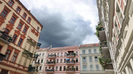 Blick auf Häuserfassaden mit Balkonen vor grauem Himmel.
