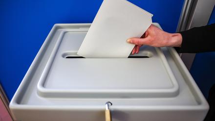 Eine Frau wirft einen Stimmzettel in eine Wahlurne. (Symbolbild)