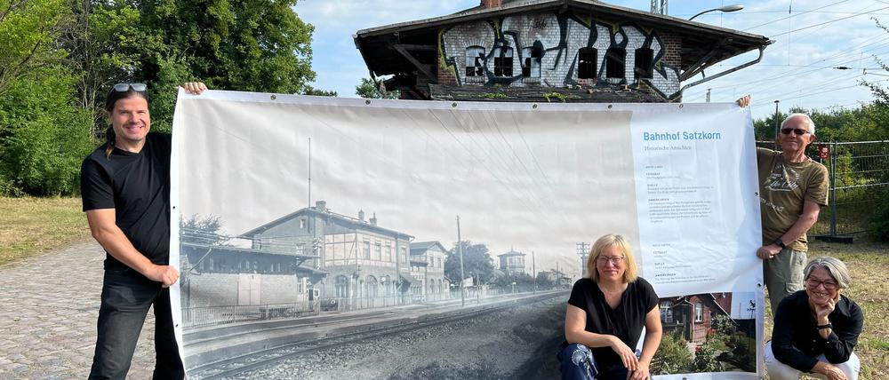 Die Ortschronisten und Ortschronistinnen von Satzkorn, Frank Grunert, Susanna Krüger, Renata Mohr, und Axel Starck (v. l.) mit einem historischen Bild des Bahnhofes.