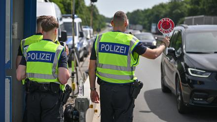 Beamte der Bundespolizei stehen auf der Autobahn A12 nahe dem deutsch-polnischen Grenzübergang und stoppen ein Auto bei der Einreise nach Deutschland.