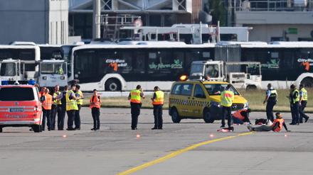 Einsatzkräfte auf dem Rollfeld des Frankfurter Flughafens. Wegen einer Aktion von Klimaaktivisten war der Flugverkehr vorläufig eingestellt worden. Mehrere Demonstranten waren am frühen Morgen auf das Gelände eingedrungen und hatten sich festgeklebt.