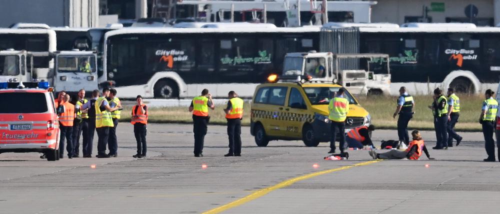 Einsatzkräfte auf dem Rollfeld des Frankfurter Flughafens. Wegen einer Aktion von Klimaaktivisten war der Flugverkehr vorläufig eingestellt worden. Mehrere Demonstranten waren am frühen Morgen auf das Gelände eingedrungen und hatten sich festgeklebt.