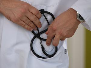 Ein Arzt hält ein Stethoskop in der Hand. 