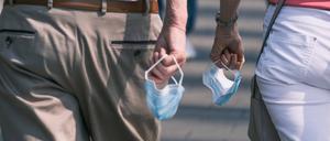 Menschen halten Masken in der Hand (Symbolbild).