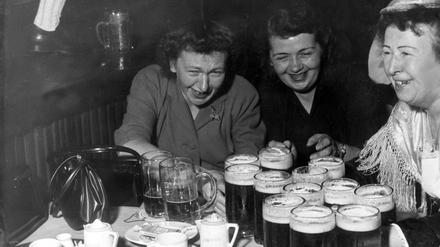 Eine Kellnerin in einem Bayerischen Lokal auf der Reeperbahn in Hamburg versorgt zwei durstige Frauen, 1950er Jahre. 