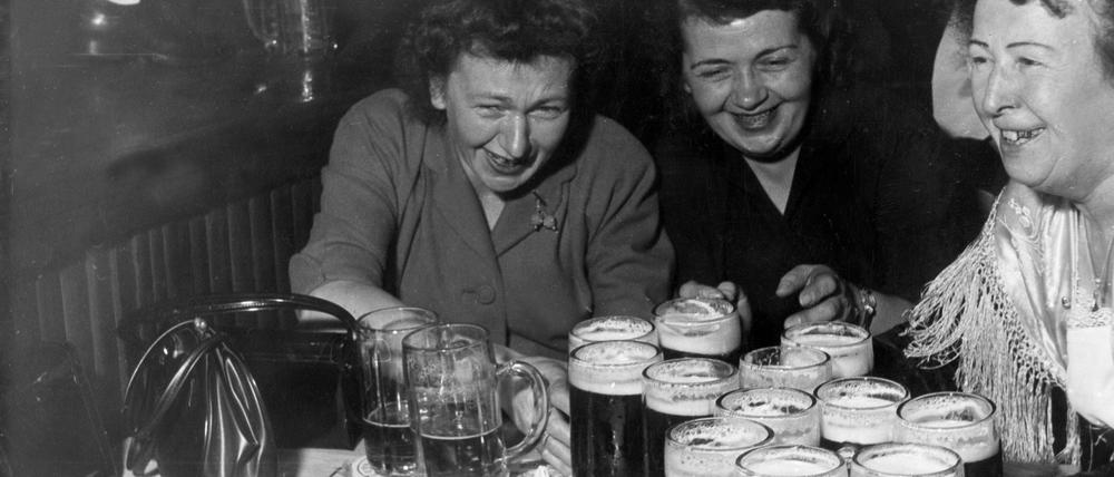Eine Kellnerin in einem Bayerischen Lokal auf der Reeperbahn in Hamburg versorgt zwei durstige Frauen, 1950er Jahre. 