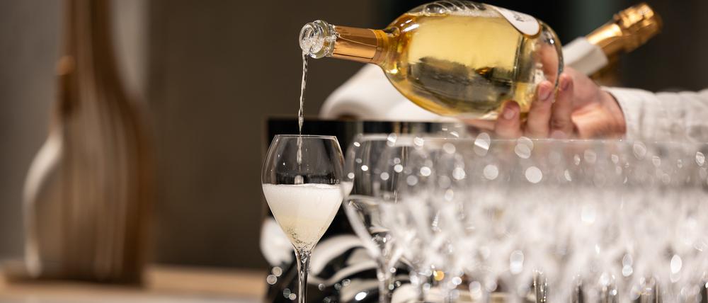 Ein Kellner schenkt ein Glas Champagner ein.