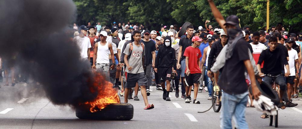 Demonstrators set a barricade on fire during a protest against Venezuelan President Nicolas Maduro's government in Valencia, Carabobo state, Venezuela on July 29, 2024, a day after the Venezuelan presidential election. Protests erupted in parts of Caracas Monday against the re-election victory claimed by Venezuelan President Nicolas Maduro but disputed by the opposition and questioned internationally, AFP journalists observed. (Photo by Juan Carlos HERNANDEZ / AFP)