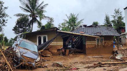 Ein beschädigtes Auto und ein Haus nach einem Erdrutsch in einem Bergdorf im Bezirk Wayanad im indischen Bundesstaat Kerala.