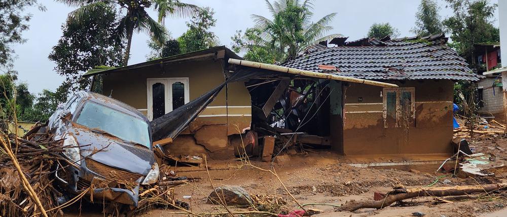 Ein beschädigtes Auto und ein Haus nach einem Erdrutsch in einem Bergdorf im Bezirk Wayanad im indischen Bundesstaat Kerala.