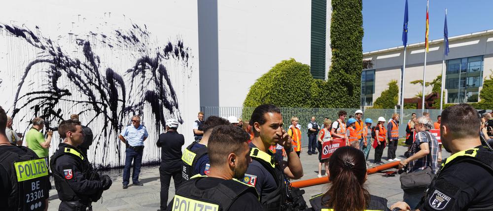  Klimaprotest am Kanzleramt 2022-06-22, Deutschland, Berlin. Spontane Protestaktion von Klimaaktivisten gegen weitere Ölbohrungen vor dem Kanzleramt, dessen südöstliche Giebelwand die Protestanten mit einer ölgleichenden Flüssigkeit besprühten. *** Climate protest at the Chancellors Office 2022 06 22, Germany, Berlin Spontaneous protest action by climate activists against further oil drilling in front of the Chancellors Office, whose southeastern gable wall the protesters sprayed with an oil-like liquid