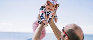 Ein Vater hält sein Kind in die Luft (Symbolbild)