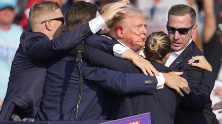 Der republikanische Präsidentschaftsbewerber und frühere US-Präsident Donald Trump wird von Agenten des US-Geheimdienstes Secret Service umringt, als ihm bei einer Wahlkampfveranstaltung von der Bühne geholfen wird (Archivbild).