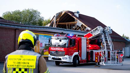 Einsatzkräfte der Feuerwehr sind bei einem eingestürzten Dach eines Supermarktes im Einsatz. 