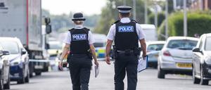 Zwei britische Polizeibeamte laufen auf einen abgesperrten Tatort zu. (Symbolbild).