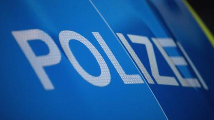 Das Wort Polizei ist auf der Karosserie eines Polizeifahrzeugs zu sehen (Symbolbild)