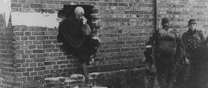 Eine Frau versucht sich während des Warschauer Aufstands in Sicherheit zu bringen, der in der deutschen Gedenkkultur eine geringe Rolle spielt.