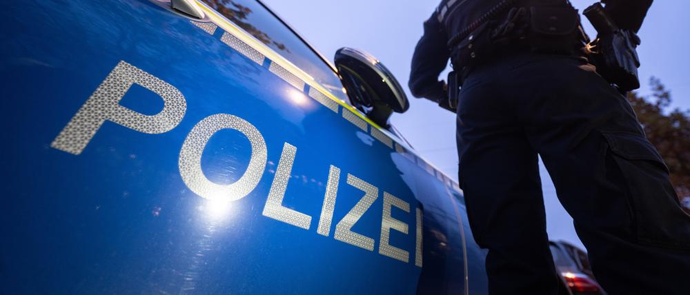 Eine Polizistin steht neben einem Polizeifahrzeug. (Symbolbild)