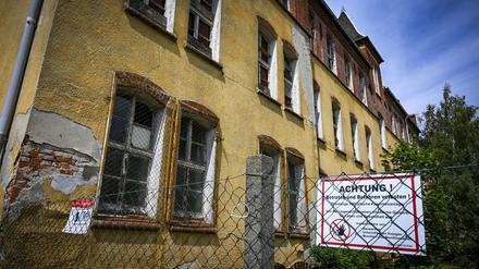 An einem Zaun an den kaiserlichen Kasernen ist ein Schild mit der Aufschrift ·Achtung! Betreten und Befahren verboten!· angebracht. 