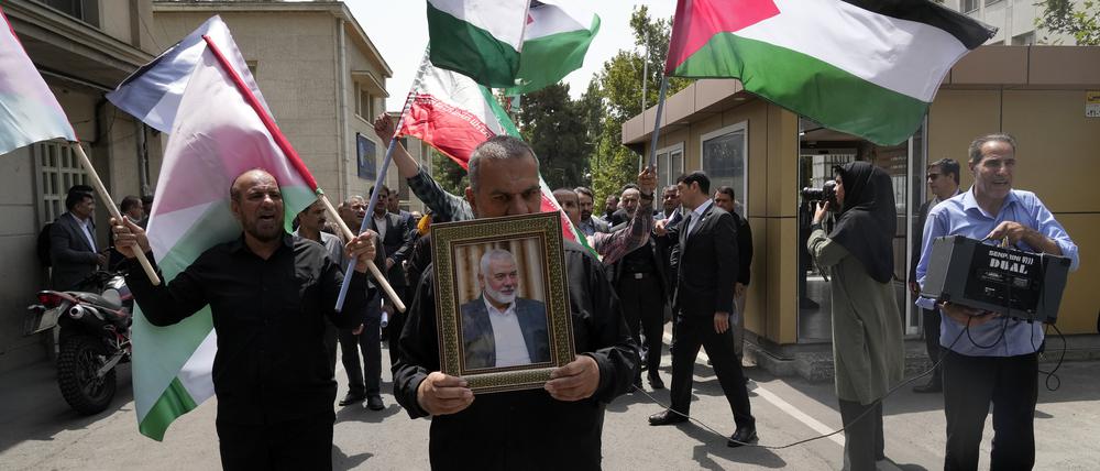 Mitglieder des Teheraner Universitätsrats tragen iranische und palästinensische Fahnen während sie an einer Protestkundgebung teilnehmen, um die Tötung des Hamas-Führers Ismail Hanija zu verurteilen. Hanija ist nach Angaben der Terrororganisation bei einem israelischen Angriff in Teheran getötet worden.