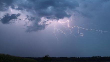 31.07.2024, Bayern, Illertissen: Ein Blitz zuckt bei einem Sommergewitter am abendlichen Himmel nördlich von Memmingen in Mittelschwaben.
