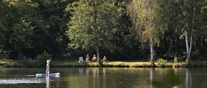 Eine Sup-Fahrerin paddelt über den Baggersee am Stern.