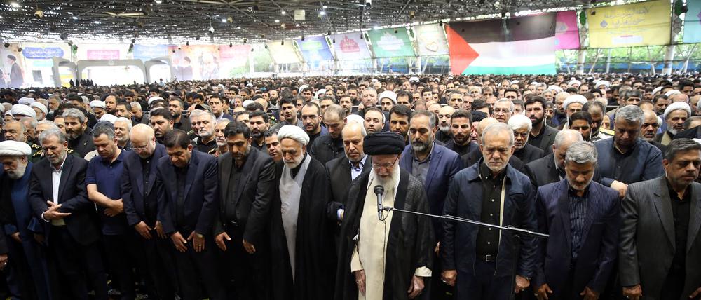 Der iranische Oberste Führer Ajatollah Ali Chamenei (M) betet über den Särgen des getöteten Hamas-Führers Ismail Hanija und seines Leibwächters während der staatlich-organisierten Trauerzeremonie an der Teheraner Universität. 