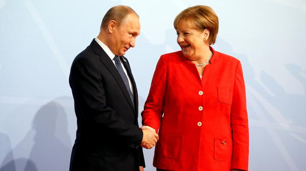 German Chancellor Angela Merkel greets Russian President Vladimir Putin as he arrives for the G20 leaders summit in Hamburg, Germany July 7, 2017. REUTERS/Axel Schmidt