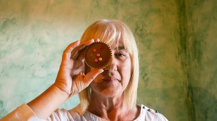 Eine Frau bedeckt ihr Auge mit einem Cupcake