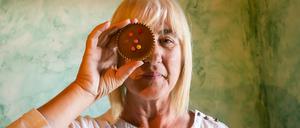 Eine Frau bedeckt ihr Auge mit einem Cupcake
