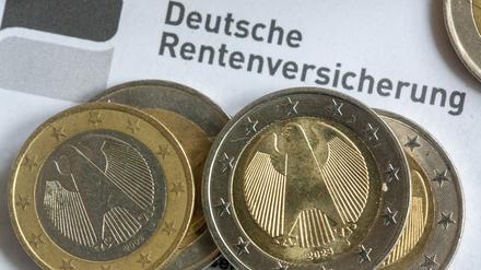 Münzen liegen auf einer Renteninformation der Deutschen Rentenversicherung.