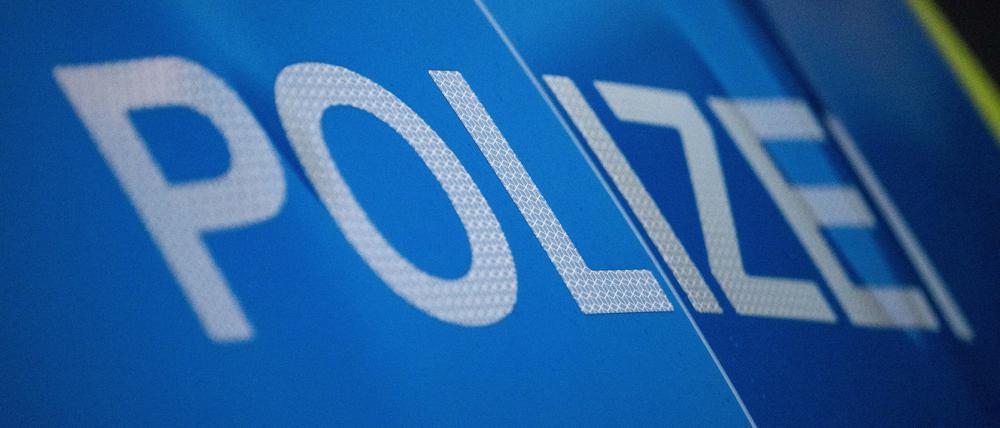 Das Wort Polizei ist auf der Karosserie eines Polizeifahrzeugs zu sehen.