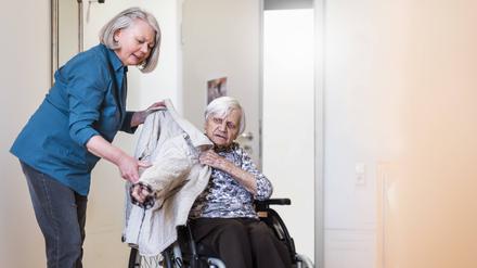 Eine Pflegekraft hilft einer Patientin: Experten fordern grundlegende Veränderungen des Systems, um eine Kostenexplosion zu vermeiden.