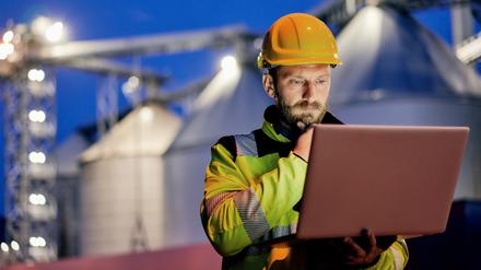 Ein Mann arbeitet am Laptop auf einer Baustelle