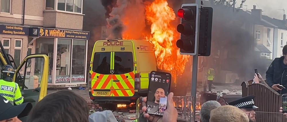 Ein Fahrzeug der Polizei brennt während Unruhen in der Nähe von Southport.