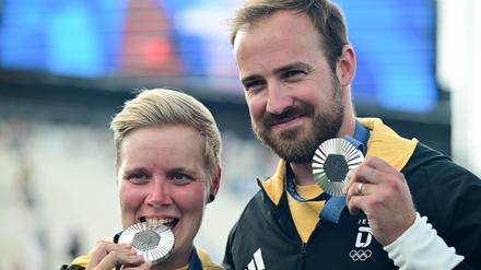 Die Bogenschützen Florian Unruh und Michelle Kroppen jubeln über Silber nach der Siegerehrung. 