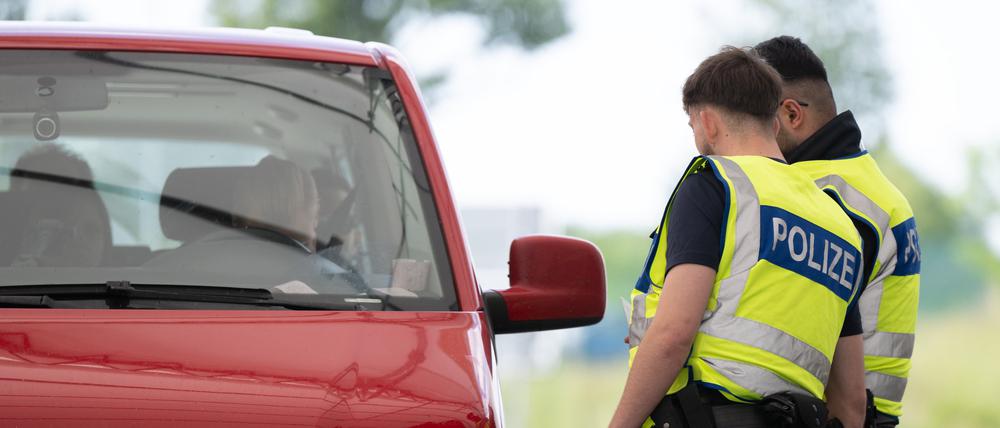 Bundespolizisten stehen bei Grenzkontrollen auf dem Rastplatz ·Am Heideholz· an der Autobahn 17 nahe der deutsch-tschechischen Grenze an einem Kleinbus.