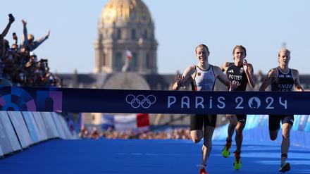 Die Deutsche Laura Lindemann beim Zieleinlauf vor der Britin Beth Potter und Taylor Knibb aus den USA auf der Pont Alexandre III in Paris.