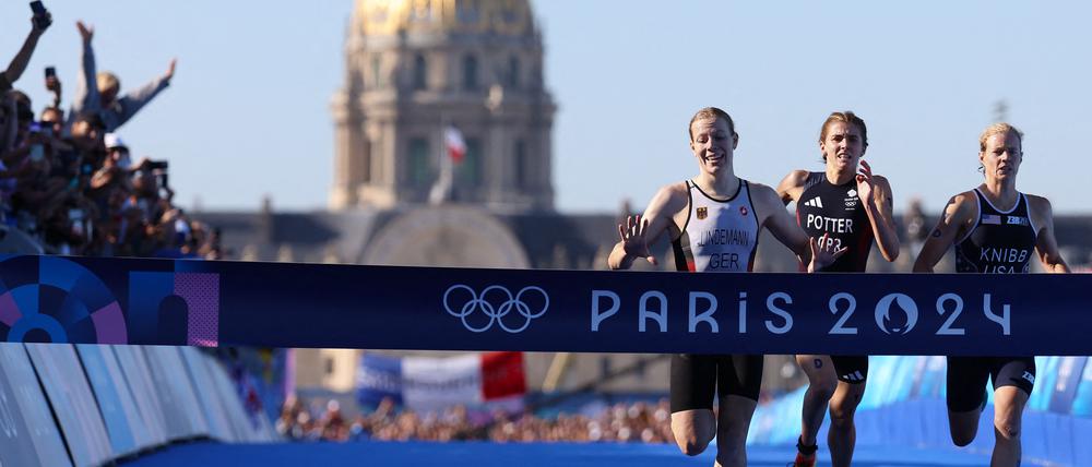 Die Deutsche Laura Lindemann beim Zieleinlauf vor der Britin Beth Potter und Taylor Knibb aus den USA auf der Pont Alexandre III in Paris.