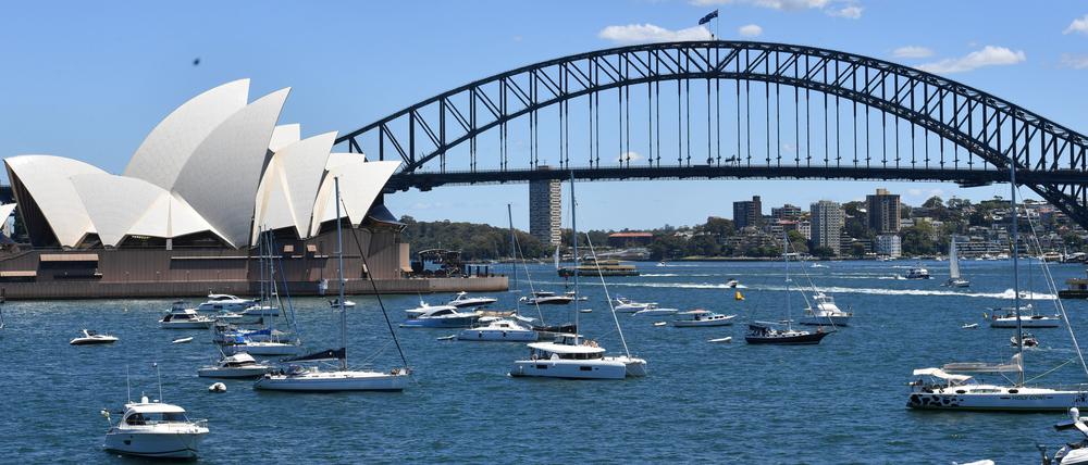 Sportboote liegen im Hafen von Sydney vor dem Opernhaus und der Sydney Harbour Bridge. 