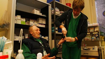 Ein Patient lässt sich in der Ambulanz der Berliner Stadtmission in der Lehrter Straße Blutdruck und Blutzucker von Krankenpfleger Stefan messen.