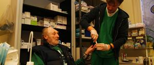 Ein Patient lässt sich in der Ambulanz der Berliner Stadtmission in der Lehrter Straße Blutdruck und Blutzucker von Krankenpfleger Stefan messen.