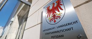 Das Metallschild neben dem Eingang zum Justizzentrum mit dem roten Adler als Landeswappen und dem Verweis auf Amtsgericht, Landgericht und Staatsanwaltschaft.