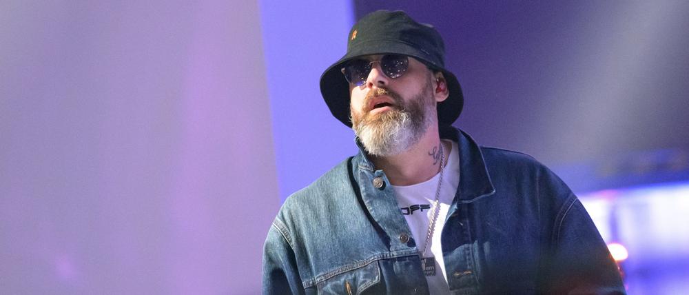 Rapper Sido mit Sonnenhut und Sonnenbrille auf einer Bühne.
