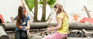 Zwei Mädchen spielen im Sommercamp Karten, die Stimmung scheint nur leicht gedrückt, wie bei den Anbietern solcher Camps auch. 