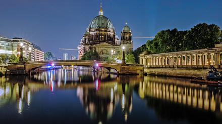 Der Dom und die Friedrichsbrücke spiegeln sich im Wasser der Spree. 